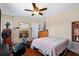 Comfortable bedroom with a fireplace, ceiling fan and hardwood flooring at 11803 70Th St, Largo, FL 33773