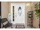 View of the front door with white frame, sidelight windows, welcome mat, and decorations at 11803 70Th St, Largo, FL 33773