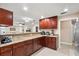 Open concept kitchen with dark cabinets, granite counters, stainless appliances, and views of the living area at 11803 70Th St, Largo, FL 33773