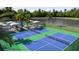 Aerial view of outdoor pickleball courts, shaded picnic areas, and a serene pond, perfect for recreation at 12553 Lily Quartz Loop, Parrish, FL 34219