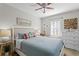 Cozy bedroom with a ceiling fan, dresser, art, and a window at 145 38Th Ne Ave, St Petersburg, FL 33704