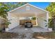 Carport with room for one car, rear access door, and mature landscaping at 145 38Th Ne Ave, St Petersburg, FL 33704