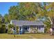 Charming single-story home featuring a yellow door, manicured lawn and mature trees at 145 38Th Ne Ave, St Petersburg, FL 33704