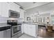Bright white kitchen featuring stainless steel appliances, granite countertops and open to the cozy living area at 145 38Th Ne Ave, St Petersburg, FL 33704