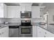 Bright kitchen offers stainless steel appliances, subway tile backsplash, granite countertops and white cabinetry at 145 38Th Ne Ave, St Petersburg, FL 33704