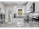 Well-lit kitchen boasts stainless steel appliances, white cabinetry and granite countertops with backyard views at 145 38Th Ne Ave, St Petersburg, FL 33704
