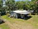 Backyard of the home featuring a covered patio, mature landscaping, and outdoor living space at 14620 Geneva Dr, Odessa, FL 33556