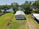 Exterior of the home with a metal roof surrounded by a well-maintained yard and lake view at 14620 Geneva Dr, Odessa, FL 33556