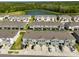 An aerial view showcasing the community with lush green spaces and a serene pond at 1504 Colt Creek Pl, Wesley Chapel, FL 33543