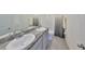 Bathroom features a double sink with granite countertop and a shower behind a grey shower curtain at 1504 Colt Creek Pl, Wesley Chapel, FL 33543