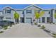Exterior view of a multi-unit building with a long driveway and gray facade at 1504 Colt Creek Pl, Wesley Chapel, FL 33543
