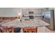 Kitchen island featuring a stainless steel sink, granite counters, seating, and stainless steel appliances in the background at 1504 Colt Creek Pl, Wesley Chapel, FL 33543