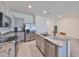 Bright kitchen showcasing stainless steel appliances, granite countertops, a kitchen island with a stainless steel sink, and grey cabinets at 1504 Colt Creek Pl, Wesley Chapel, FL 33543