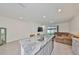 Spacious living room flowing to a kitchen featuring stainless steel appliances, granite counters, and tile floors at 1504 Colt Creek Pl, Wesley Chapel, FL 33543