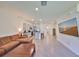 Bright living room flowing to kitchen showcasing stainless steel appliances, granite counters, and a large brown sectional sofa at 1504 Colt Creek Pl, Wesley Chapel, FL 33543