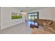 Living area featuring a large brown sectional, sliding glass doors to the yard, tile flooring, and stairs to the second floor at 1504 Colt Creek Pl, Wesley Chapel, FL 33543