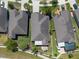 An aerial shot offering a detailed perspective of rooftop, yard layout, and backyard patio of the single Gathering homes at 16331 Treasure Point Dr, Wimauma, FL 33598