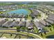 Overhead shot showcases backyards and community walkways with a scenic pond, blending residential comfort with natural beauty at 16331 Treasure Point Dr, Wimauma, FL 33598