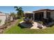 Well-maintained backyard featuring a stone-paved patio with a dining set, surrounded by lush landscaping at 16331 Treasure Point Dr, Wimauma, FL 33598