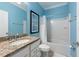 Bathroom with blue walls, a granite countertop, and a combined shower and bathtub at 16331 Treasure Point Dr, Wimauma, FL 33598