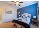Charming bedroom with beach themed decor, ceiling fan, and blue accent wall at 16331 Treasure Point Dr, Wimauma, FL 33598