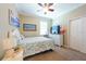 Bright bedroom with a white dresser, ceiling fan, and closet with sliding doors at 16331 Treasure Point Dr, Wimauma, FL 33598