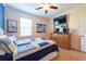 Cozy bedroom with a light colored carpet, a ceiling fan, and a wooden dresser at 16331 Treasure Point Dr, Wimauma, FL 33598