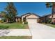 Inviting single-Gathering home with manicured lawn, colorful landscaping, and a two-car garage at 16331 Treasure Point Dr, Wimauma, FL 33598