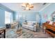 Cozy living room featuring light-blue walls, a ceiling fan, and charming coastal-themed decor at 16331 Treasure Point Dr, Wimauma, FL 33598
