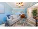 Inviting living room with a neutral couch, ceiling fan, and beach themed decor at 16331 Treasure Point Dr, Wimauma, FL 33598