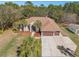 Beautiful home with a three-car garage, and a well-manicured lawn and driveway in a treed lot at 16340 Marquis Rd, Brooksville, FL 34614