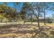 Spacious backyard featuring mature trees, lawn and partial view of a screened-in lanai at 16340 Marquis Rd, Brooksville, FL 34614