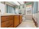 A traditional bathroom with a single sink vanity, tile flooring, and framed wall art at 16340 Marquis Rd, Brooksville, FL 34614