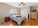 Cozy bedroom features a ceiling fan, hardwood floors, and a dresser with a TV at 16340 Marquis Rd, Brooksville, FL 34614