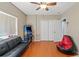 Bedroom featuring an arcade machine, futon, closet, and hardwood floors at 16340 Marquis Rd, Brooksville, FL 34614