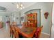 Bright dining room featuring an ornate cabinet, modern chandelier, and a large wood table at 16340 Marquis Rd, Brooksville, FL 34614
