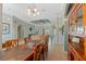 Dining area with an ornate cabinet, modern chandelier, and an open view of the living room at 16340 Marquis Rd, Brooksville, FL 34614