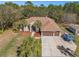 Aerial view of the property, showcasing the well-manicured lawn, large driveway, and mature trees at 16340 Marquis Rd, Brooksville, FL 34614