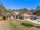 Charming single-story home with well-manicured lawn, large driveway, and mature trees at 16340 Marquis Rd, Brooksville, FL 34614