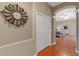 Hallway view with hardwood floors leading to a bedroom with a comfy bed and lots of natural light at 16340 Marquis Rd, Brooksville, FL 34614