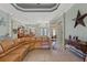 Inviting living room with a brown leather couch and large windows, showcasing the open layout of the home at 16340 Marquis Rd, Brooksville, FL 34614