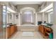 Luxurious bathroom features a large soaking tub, columns, tile floors, and dual vanities at 16340 Marquis Rd, Brooksville, FL 34614