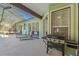 Covered patio with grill, lounge chairs, and screened-in pool, perfect for entertaining and relaxation at 16340 Marquis Rd, Brooksville, FL 34614