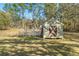 Backyard shed featuring a charming design, wooden door, and a picket fence for a cozy outdoor space at 16340 Marquis Rd, Brooksville, FL 34614
