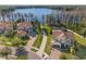 Aerial view of waterfront homes with tile roofs and lush landscaping near a tranquil lake at 16532 Ballyshannon Dr, Tampa, FL 33624