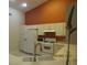 Bright kitchen with white appliances and cabinets, with an orange accent wall at 21537 Clubside Loop, Lutz, FL 33549