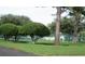 Well-manicured landscaping with shade trees and greenery alongside a tennis court and grassy lawn at 21537 Clubside Loop, Lutz, FL 33549