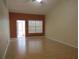Open living room with wood floors, orange wall, and lots of natural light at 21537 Clubside Loop, Lutz, FL 33549