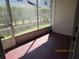 Screened-in porch featuring a red painted floor and sliding screen door leading to landscaped backyard at 21537 Clubside Loop, Lutz, FL 33549