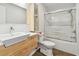 Bright bathroom with wood vanity, modern sink, toilet and glass enclosed tub/shower combination at 2259 Costa Rican Dr # 23, Clearwater, FL 33763